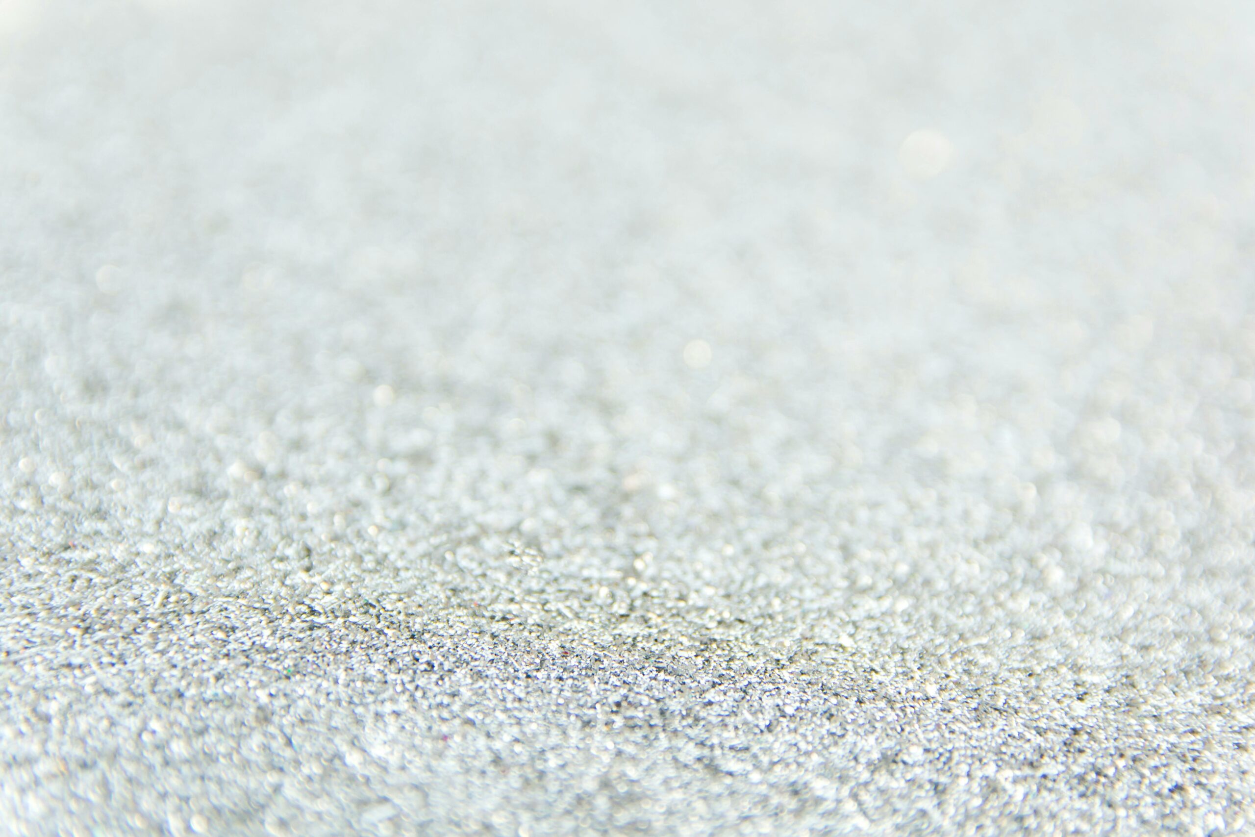 Close-up of defocused silver glitter creating a sparkling textured background.